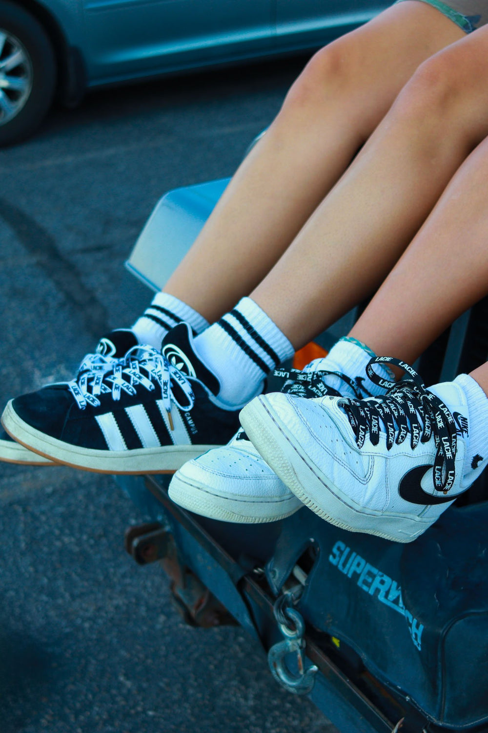 Sneakers with LACIE laces resting on a truck tailgate