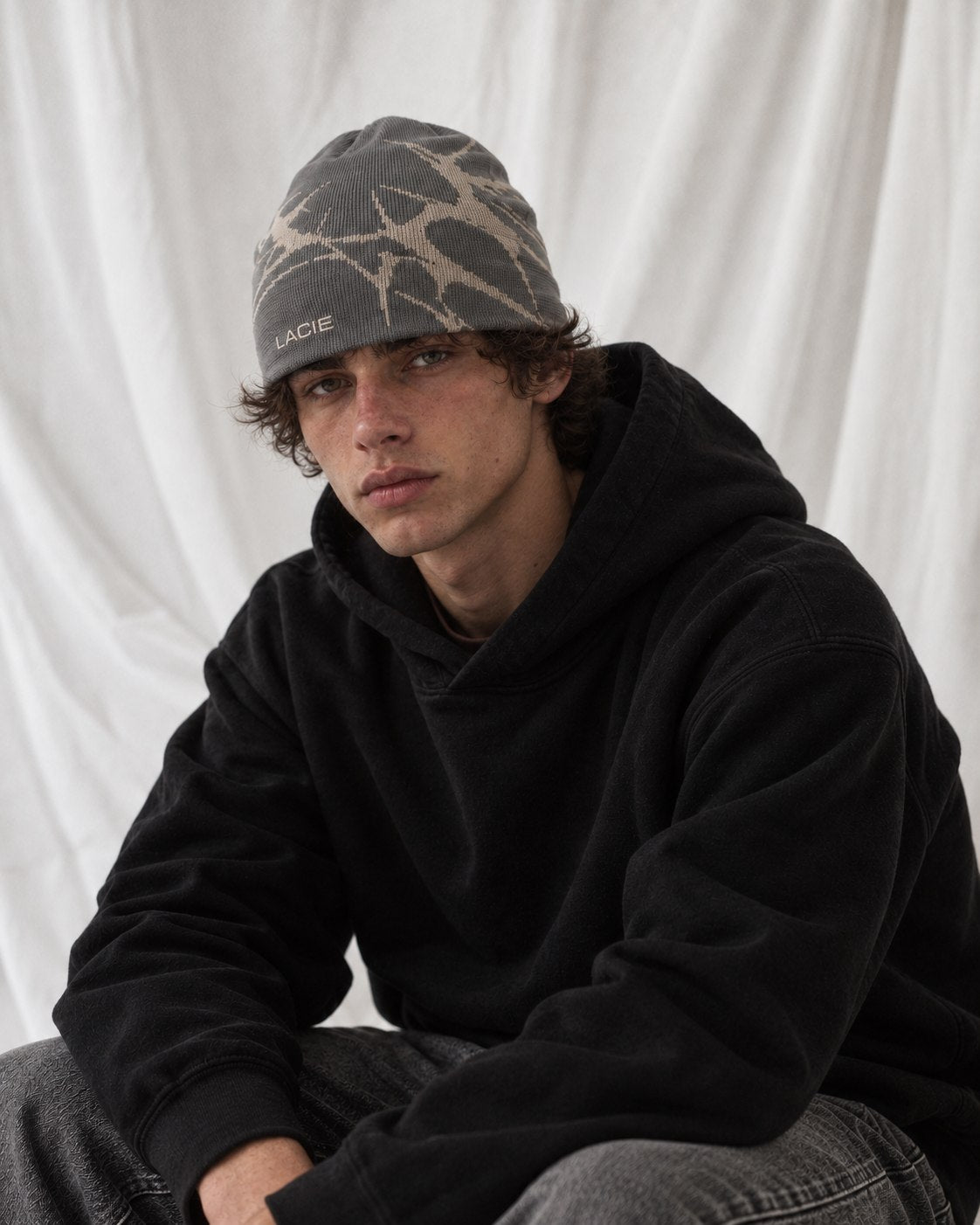 Studio portrait in a black hoodie wearing the LACIE Thorn Beanie